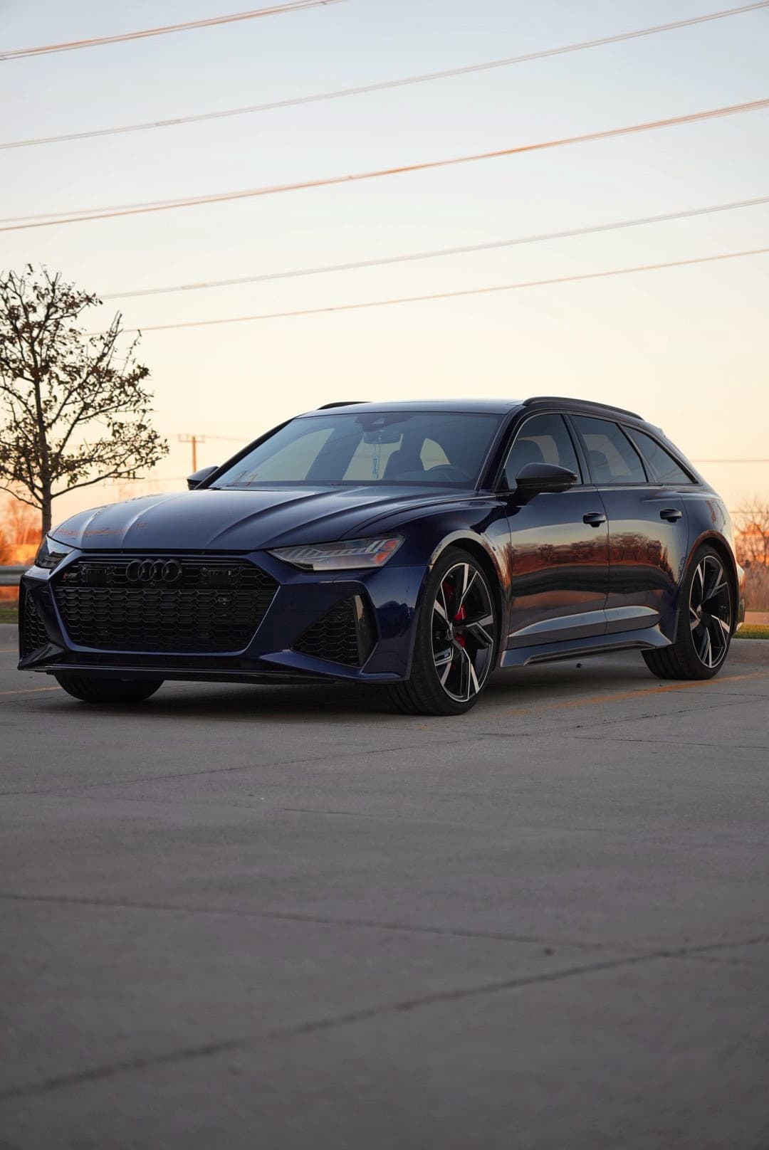 Audi RS6 Avant in Navarra blue, front three-quarter at sunset