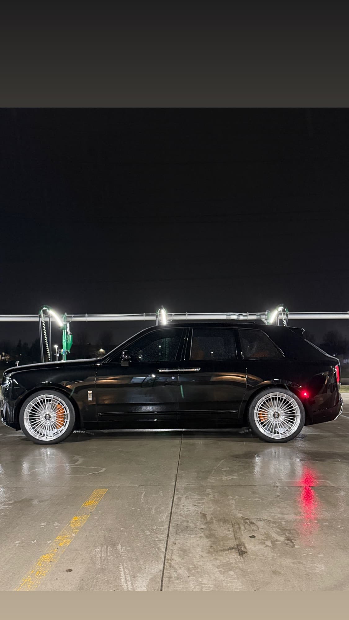 Rolls Royce Cullinan side profile at night, full body STEK PPF install with gloss finish catching the overhead lights