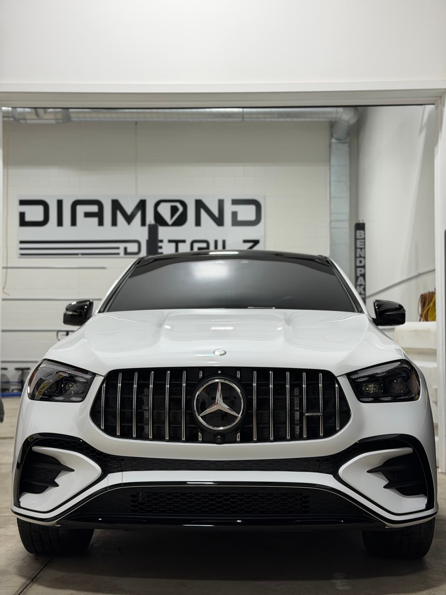 White Mercedes-AMG GLE coupe, head-on, inside the Diamond Detailz bay