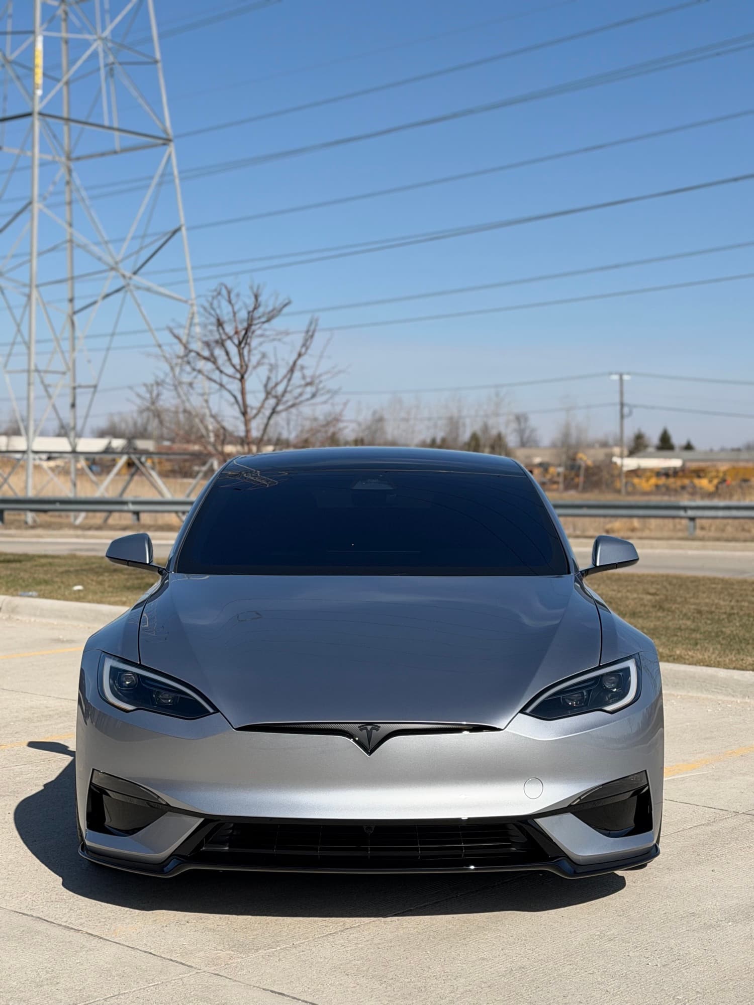 Silver Tesla Model S Plaid, head-on, in a parking lot
